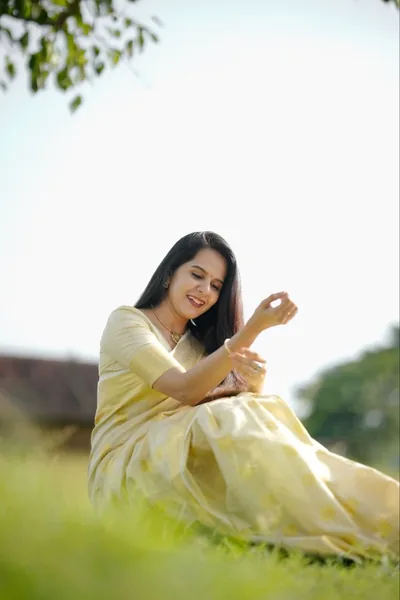 Ivory-and-gold set saree in an open field